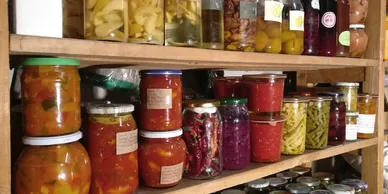 Shelves filled with home-canned fruits, vegetables, and preserves as part of a food preparedness pantry.
