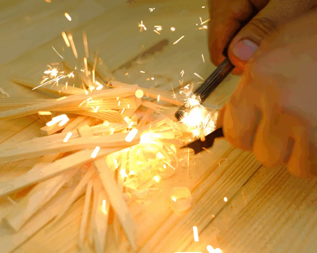 Close-up of hands using a ferro rod to spark a fire over kindling to show fire starting tips